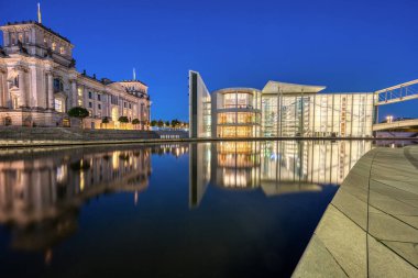 Reichstag 'ın bir kısmı ve Paul-Loebe-Haus nehrinin kıyısında. Geceleri Berlin' de Spree nehrinde.