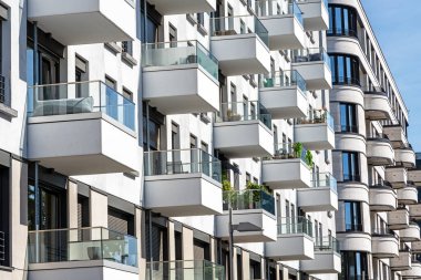 Berlin, Almanya 'da birçok küçük balkonu olan beyaz, modern bir apartmanın ön cephesi.