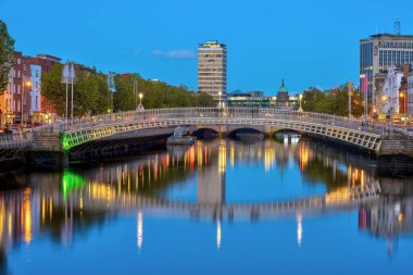 Liffey nehri ve İrlanda, Dublin 'deki ünlü yarım peni köprüsü, alacakaranlıkta.