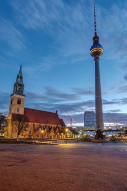 Şafakta Berlin 'deki Alexanderplatz' daki ünlü TV Kulesi ve St. Mary Kilisesi.