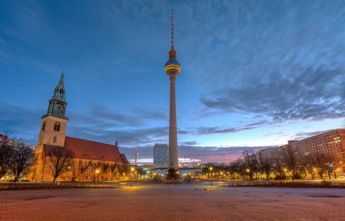 Berlin 'deki Alexanderplatz' da ünlü Televizyon Kulesi ve Marienkirche ile güneş doğmadan önce.