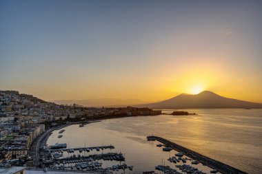 Naples and the Gulf of Naples in Italy with the sun rising right behind Mt Vesuvius