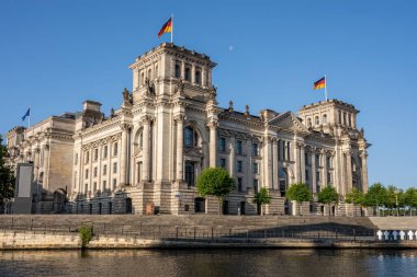 Güneşli bir günde Berlin 'de Spree nehrindeki tarihi Reichstag