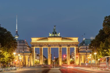 Brandenburg Kapısı. Berlin 'de alacakaranlıkta televizyon kulesi var.