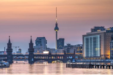 Berlin ve nehir. Gün batımından sonra Oberbaum Köprüsü ve ünlü Televizyon Kulesi ile birlikte.