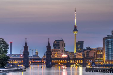 Berlin 'de Oberbaum köprüsü ve alacakaranlıkta TV kulesi olan Spree Nehri.