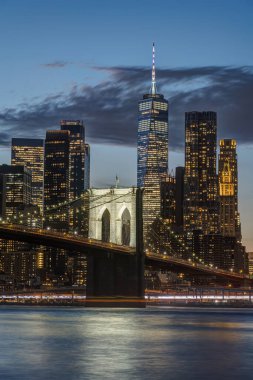 Brooklyn Köprüsü ve New York 'ta alacakaranlıkta aşağı Manhattan' ın silueti.