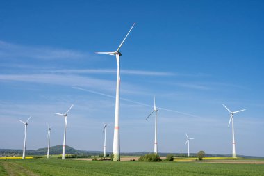 Almanya 'da yeşil tarım alanlarına sahip modern rüzgar enerjisi santralleri görülüyor