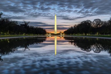Şafak vakti ünlü Washington Anıtı ünlü yansıtma havuzuna yansıdı.