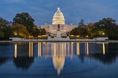 Washington DC 'deki aydınlık Birleşik Devletler Kongre Binası. Alacakaranlıkta ünlü yansıma havuzuyla.