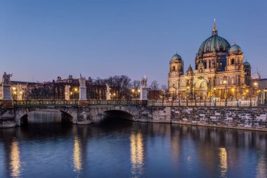 Berlin Katedrali ve gece bir kanalın üzerindeki köprü.