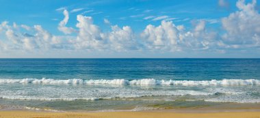 Parlak okyanus manzarası. Deniz dalgaları ve beyaz bulutlu güzel gökyüzü.