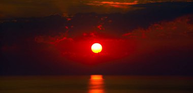 Okyanusta güneşli kızıl gün doğumu