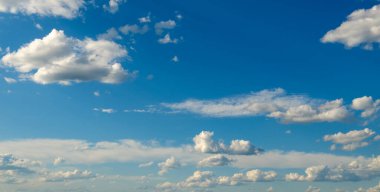 Parlak mavi gökyüzünde beyaz kabarık bulutlar.