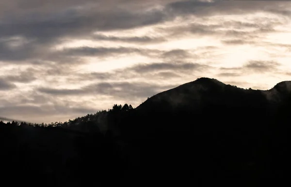 Silhouet Van Een Bergketen Bij Zonsondergang Met Heldere Wolken — Stockfoto