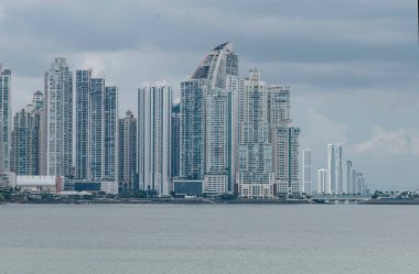 Modern skyline of Panama City, Panama, with tall skyscrapers rising along the waterfront. The mix of contemporary highrise architecture stands against a cloudy sky, reflecting the city's growth  
