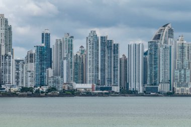 Modern skyline of Panama City, Panama, with tall skyscrapers rising along the waterfront. The mix of contemporary highrise architecture stands against a cloudy sky, reflecting the city's growth  