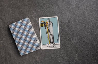 9 Kasım 2022 - Kyiv, Ukrayna. Tarot 'un kıdemli (daha yüksek) arcana' sı. İX, 9, 9 Münzevi. Gri taşlı arka planda fal bakımı için özel tarot kartları