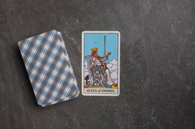 9 Kasım 2022 Ukrayna, Kyiv. Ryder 'ın Tarot' u... Kılıç takımının Junior Arcana 'sı. Kraliçe. Gri taşlı arka planda fal bakımı için özel tarot kartları