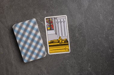 9 Kasım 2022 Ukrayna, Kyiv. Ryder 'ın Tarot' u... Kılıç takımının Junior Arcana 'sı. Dört, VI, dört. Gri taşlı arka planda fal bakımı için özel tarot kartları