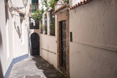 Güney İtalya 'nın Amalfi şehrindeki tarihi, pejmürde, romantik sokaklar. Eski sokaklar, virajlar, yaz güneşiyle dolu kapılar. Orta Çağ Avrupa turizmi.