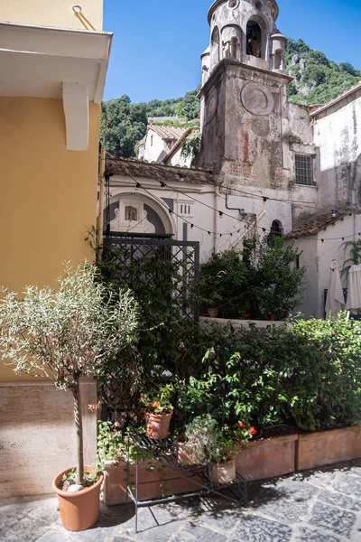 アマルフィ市内の南イタリアの古い歴史的なみすぼらしいロマンチックな通り 狭いヴィンテージの通り ターン 夏の太陽の下で入浴し 緑の木々に囲まれたドア 中世ヨーロッパ観光 — ストック写真
