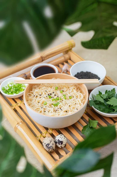 白い竹皿 に卵麺と具材を入れたものを 軽い背景を持つ竹皿に盛り付ける アジアの伝統的なファーストフード — ストック写真