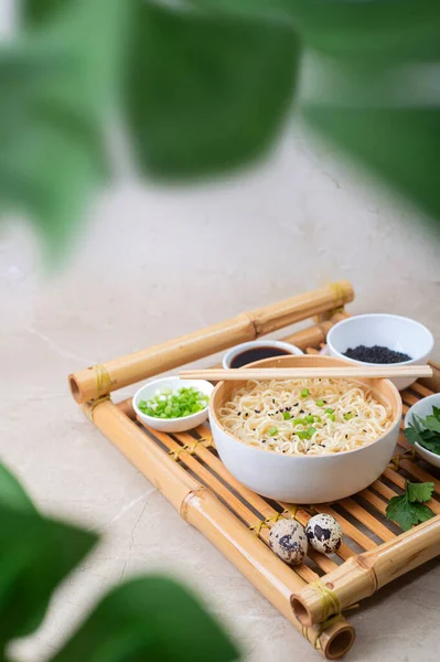 白い竹皿 に卵麺と具材を入れたものを 軽い背景を持つ竹皿に盛り付ける アジアの伝統的なファーストフード — ストック写真