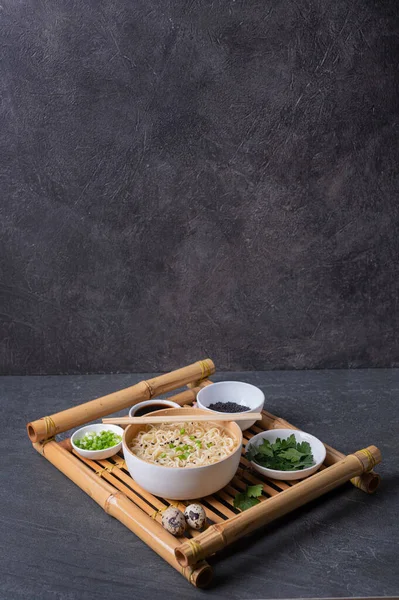 白い竹の板 ボウル 卵麺とそれのための材料とプレート暗い大理石 スレート の背景にトレイを提供竹の上に アジアの伝統的なファーストフード — ストック写真