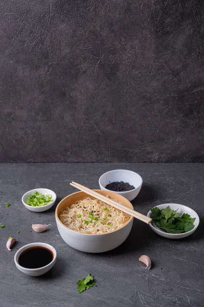 黒い大理石 スレート の背景に 卵麺と具材を入れた白い竹板 ボウル アジアの伝統的なファーストフード — ストック写真