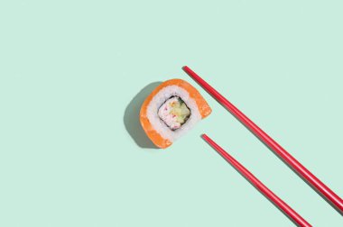 Japon somon balığı, pastel yeşil arka planda kırmızı çubuklu ejderha sarmaları. Pop sanat. Asya geleneksel yemekleri