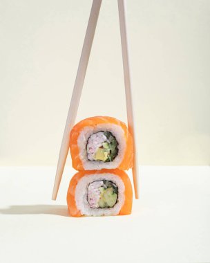 Bir çift Japon somonu suşisi, parlak sarı bir zemin üzerinde ejderha yuvarlanıyor. Pop sanat. Lezzetli abur cuburlar. Asya geleneksel yemekleri