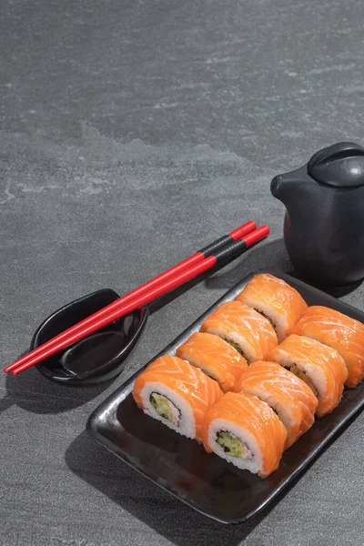 寿司卷与鲑鱼 鳄梨和黄瓜在黑色矩形板黑色石头 亚洲传统食品 — 图库照片
