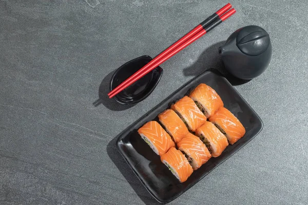 Rollos Sushi Con Salmón Aguacate Pepino Sobre Plato Rectangular Negro — Foto de Stock