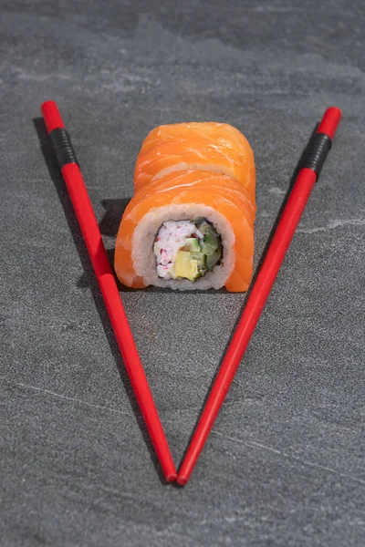 Sushi Rola Com Salmão Abacate Pepino Com Pauzinhos Vermelhos Sobre — Fotografia de Stock