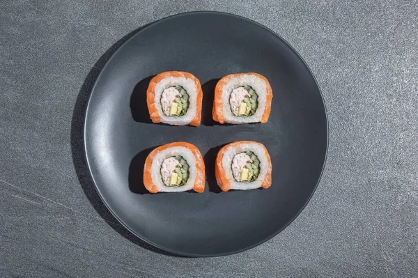 Rollos Sushi Con Salmón Aguacate Pepino Sobre Plato Redondo Negro — Foto de Stock