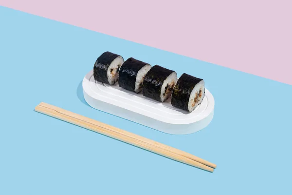 Hosomaki Sushi Úhořem Bílém Stojanu Barevném Prostém Pozadí Modré Růžové — Stock fotografie