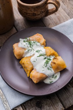 Ukrainian traditional dish of national cuisine - holubtsi. A plate with cabbage rolls on a dark wooden background
