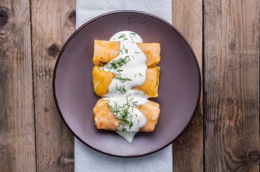 Ukrainian traditional dish of national cuisine - holubtsi. A plate with cabbage rolls on a dark wooden background