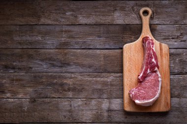 Ahşap bir tahtanın üzerindeki çiğ domuz filetosunun kırsal cazibesine kapıl. Bu ağız sulandırıcı yemek, lezzetli tatları kırsal bir sunumla birleştirip bir mutfak başyapıtı oluşturuyor.