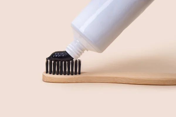 White Tube Black Toothpaste Bamboo Brush Black Bristles Beige Background — Stock Photo, Image