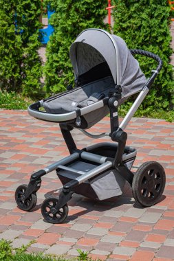 Modern gri bebek arabası bahçede..