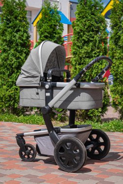 Modern gri bebek arabası bahçede..