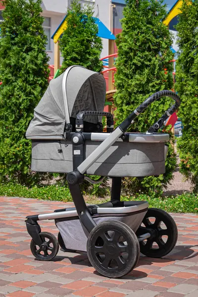 Modern gri bebek arabası bahçede..