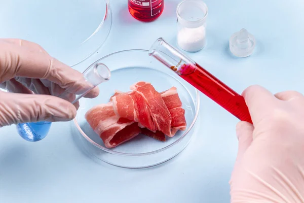 培育的肉 玻璃杯中的培根 人工肉类的实验室研究 化学品库存图像 图库图片