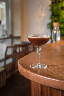 Espresso martini. Modern bir ahşap stantta kadehte kokteyl.