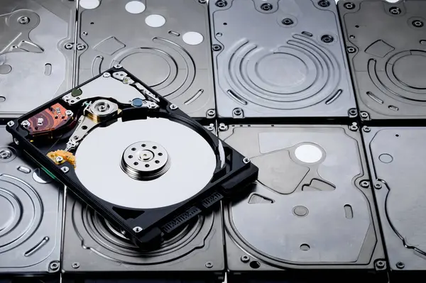 Kapağı kaldıran bir sabit diskin görüntüsü içerideki manyetik diski gösterir ve birçok eşleşmeye yerleştirir.