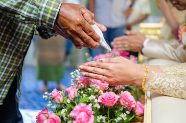 Thai düğününde kutsal su dökmek