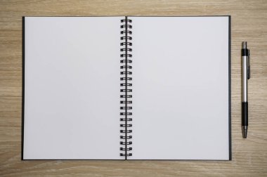 boş sayfası olan bir defter ahşap masada açıldı