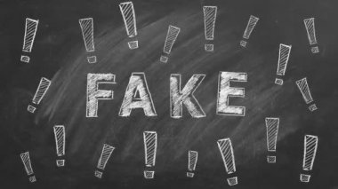 The word FAKE and exclamation marks written in chalk on a blackboard. Information and disinformation concept. Fake news.